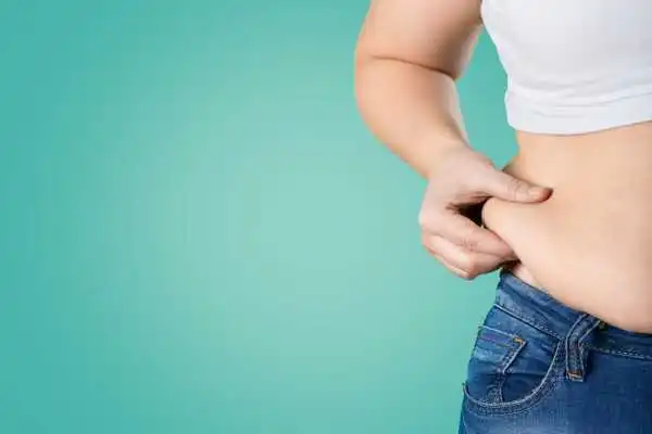Image of woman pinching her love handles to show weight gain Bishops Stortford